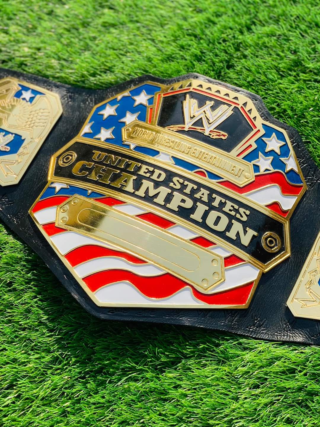 WWE United States Championship belt on a grass background